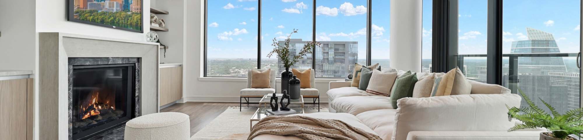 Interior of luxury apartment with fireplace and view of city through windows